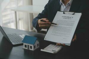 Real estate agent and customer signing contract to buy house, insurance or loan real estate.rent a house,get insurance or loan real estate or property. photo