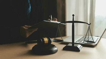 Business and lawyers discussing contract papers with brass scale on desk in office. Law, legal services, advice, justice and law concept picture with film grain effect photo