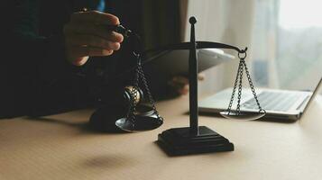 Business and lawyers discussing contract papers with brass scale on desk in office. Law, legal services, advice, justice and law concept picture with film grain effect photo