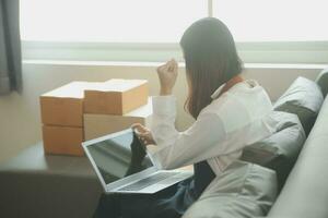 mujer de negocios puesta en marcha empresaria de pequeña empresa sme éxito. mujer independiente que trabaja en casa con entrega de paquetes en línea. concepto de entrega de pymes y embalajes foto