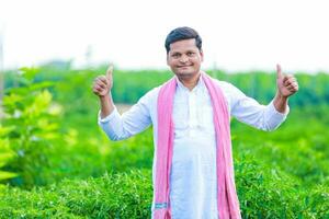 Indian Happy farmer holding green chilli , green chilli farming, young farmer photo