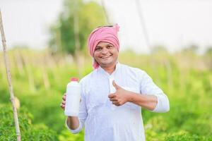 farmer showing empty bottal in hands , happy farmer , green chilli farmingt, photo