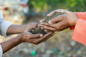 Indian farmer holding soil in hands, happy farming, Dropping soil in other hand photo