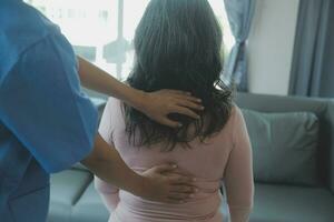 young asian physical therapist working with senior woman on walking with a walker photo