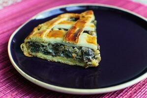 Spinach Pie on Dark Plate Selective Focus Copy Space photo