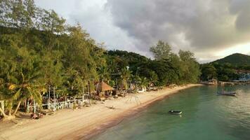 4k aéreo zumbido imágenes de sairee playa en koh tao a puesta de sol , presentando blanco arena playa, cristal claro agua, palma arboles y barcos video