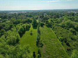 A tranquil landscape of lush green fields, rolling hills and a forest stretching out beneath the clear blue sky. photo