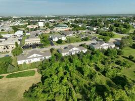 un maravilloso aéreo ver de un residencial suburbio en un soleado día, demostración el intrincado red de edificios y arboles foto