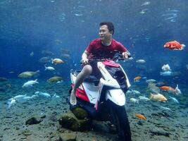 Klaten, Umbul ponggok, Indonesia, July 22, 2022,  a man taking a photo under clear water