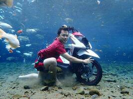 Klaten, Umbul ponggok, Indonesia, July 22, 2022,  a man taking a photo under clear water