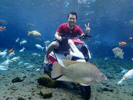 Klaten, Umbul ponggok, Indonesia, July 22, 2022,  a man taking a photo under clear water