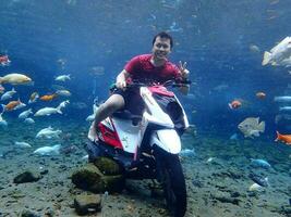 Klaten, Umbul ponggok, Indonesia, July 22, 2022,  a man taking a photo under clear water