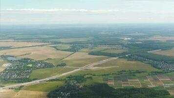 First person view from the plane window to beautiful green meadows and forests when the plane is landing. Panoramic scenic view of over countryside fields landscape in Kaliningrad video