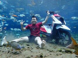 Klaten, Umbul ponggok, Indonesia, July 22, 2022,  a man taking a photo under clear water