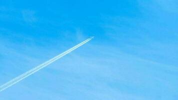 Contrails in the blue sky. Airplane flying high. Slow motion video