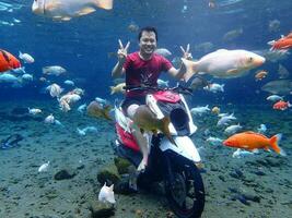 Klaten, Umbul ponggok, Indonesia, July 22, 2022,  a man taking a photo under clear water