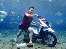 Klaten, Umbul ponggok, Indonesia, July 22, 2022,  a man taking a photo under clear water