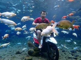 Klaten, Umbul ponggok, Indonesia, July 22, 2022,  a man taking a photo under clear water