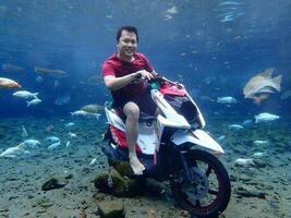 Klaten, Umbul ponggok, Indonesia, July 22, 2022,  a man taking a photo under clear water