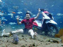 Klaten, Umbul ponggok, Indonesia, July 22, 2022,  a man taking a photo under clear water