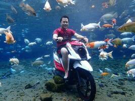 Klaten, Umbul ponggok, Indonesia, July 22, 2022,  a man taking a photo under clear water