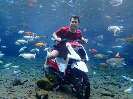 Klaten, Umbul ponggok, Indonesia, July 22, 2022,  a man taking a photo under clear water