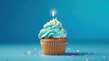 Birthday cupcake with a candle on light blue background with balloons. photo