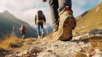 focus on shoes of cropping unreconized Hiker group of friend with trekking sticks climbs steep on mountain trail. photo