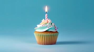 Birthday cupcake with a candle on light blue background with balloons. photo