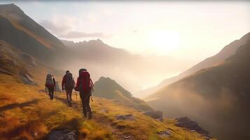 Group of hikers walks in mountains at early morning. photo