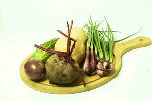 vegetales en un de madera tablero en un blanco antecedentes cerca arriba foto