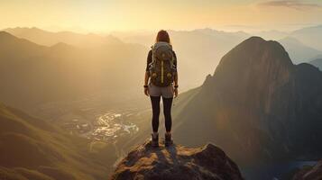 Success woman hiker hiking on sunrise mountain peak. photo