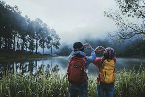 Couple lovers travel beatiful nature panorama view of Pang Ung lake in the mist at sunrise, Mae Hong Son province, Thailand. photo