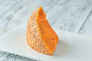 Mimolette cheese on white plate photo