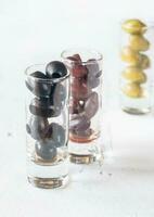 Assortment of three species of olives in glasses photo