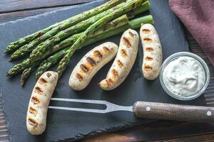 Grilled sausages with asparagus and creamy garlic sauce photo