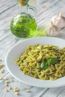 Portion of farfalle with pesto with ingredients photo