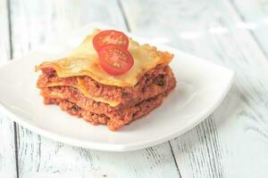 Portion of lasagne on the white plate photo