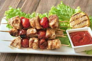 brochetas de pollo a la parrilla en el plato blanco foto