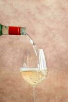 White wine pouring into glass photo