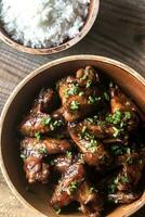 Bowl of teriyaki chicken wings with rice photo