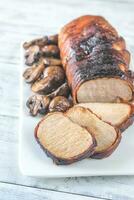 Pork loin wrapped in bacon with roasted mushrooms photo