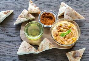 A bowl of hummus with pita slices photo