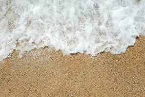 Ocean wave on sandy beach photo