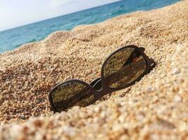 Sunglasses on the sand beach photo