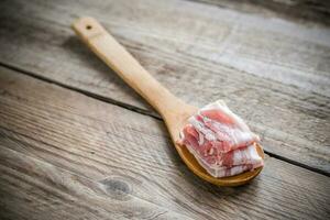 tocino tiras con pimienta en de madera cuchara foto