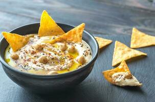 Bowl of hummus with tortilla chips photo