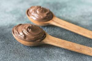 Two wooden spoons of chocolate cream photo