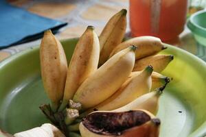 yellow and slightly rotten bananas on a green tray photo