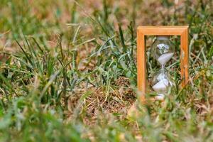 Hourglass on the grass photo